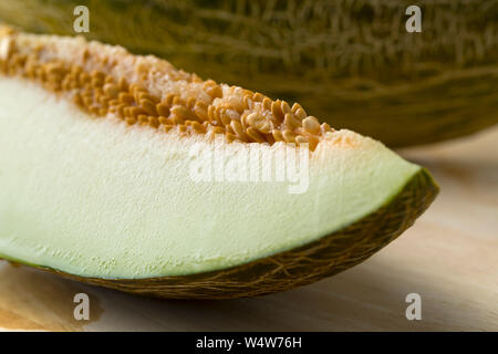 Piece of a juicy Piel de sapo melon with a blotched green peel close up Stock Photo