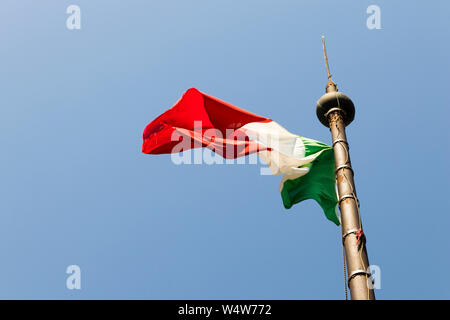 Flag of Italy waving over a blue sky on a sunny summer day on top of the tower of San Martino della Battaglia Stock Photo