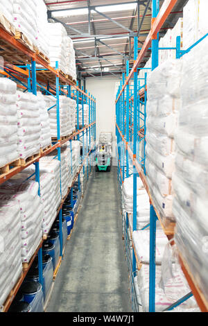 Worker driving forklift in warehouse Stock Photo
