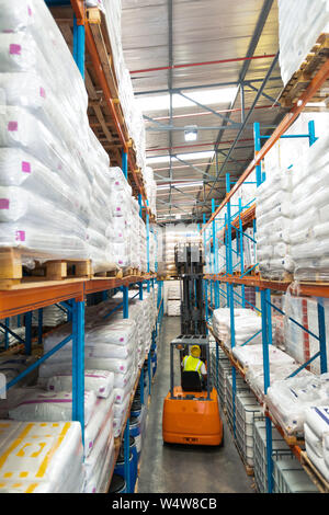 Male worker driving forklift in warehouse Stock Photo