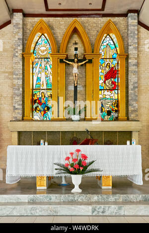 Altar and colorful painted windows inside the church of San Antonio de Padua surrounded with garden in Cuartero town, Capiz Province, Philippines Stock Photo