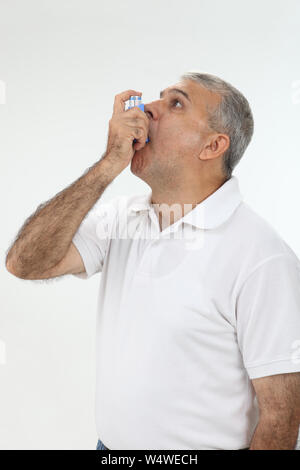 Old man using asthma inhaler Stock Photo
