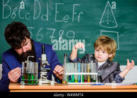 Knowledge is delicious. school kid scientist studying science. teacher man with little boy. Back to school. father and son at school. Little kid learning chemistry in school laboratory. Stock Photo