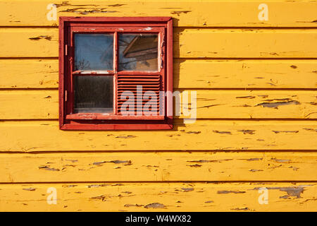 Yellow and red wooden background of peeling cracked surface. Abstract pattern in rustic style with window Stock Photo