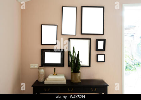 collection of various blank black frames on wall with modern decoration, green plant in a lovely home Stock Photo