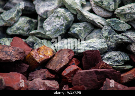 The combination of gray and dark red, natural background, decorative stones, aquarium stones, stones for the garden, landscape design Stock Photo