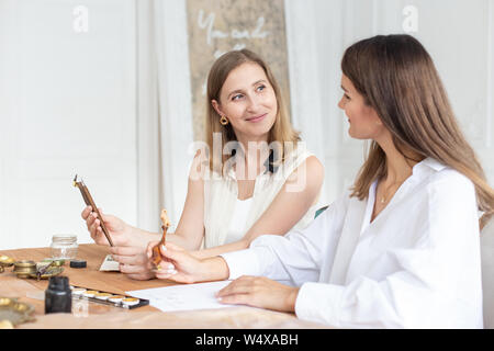 Learning calligraphy in art workshop. Teacher and students. Art school handwriting Stock Photo
