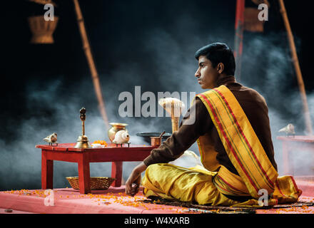 Varanasi, INDIA - CIRCA NOVEMBER 2018: Young priest performing the Ganga Aarti ceremony at the  Assi Ghat in Varanasi. The Aarti is a powerful and upl Stock Photo