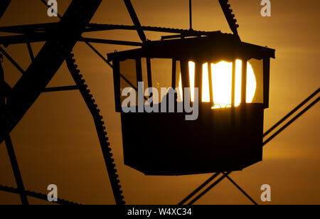 Munich, Germany. 25th July, 2019. The sun sets behind a big wheel in the Olympic Park. Credit: Sven Hoppe/dpa/Alamy Live News Stock Photo