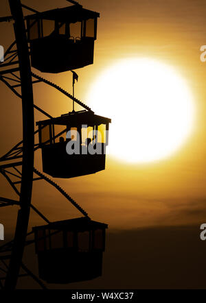 Munich, Germany. 25th July, 2019. The sun sets behind a big wheel in the Olympic Park. Credit: Sven Hoppe/dpa/Alamy Live News Stock Photo