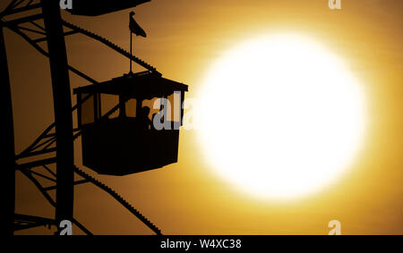 Munich, Germany. 25th July, 2019. The sun sets behind a big wheel in the Olympic Park. Credit: Sven Hoppe/dpa/Alamy Live News Stock Photo