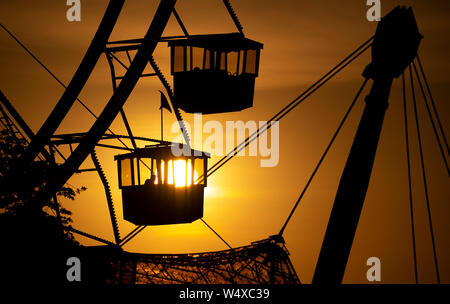 Munich, Germany. 25th July, 2019. The sun sets behind a big wheel in the Olympic Park. Credit: Sven Hoppe/dpa/Alamy Live News Stock Photo