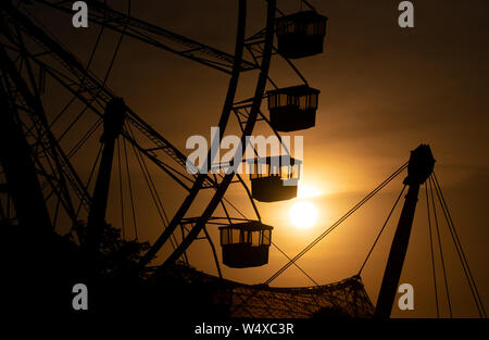 Munich, Germany. 25th July, 2019. The sun sets behind a big wheel in the Olympic Park. Credit: Sven Hoppe/dpa/Alamy Live News Stock Photo