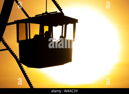 Munich, Germany. 25th July, 2019. The sun sets behind a big wheel in the Olympic Park. Credit: Sven Hoppe/dpa/Alamy Live News Stock Photo