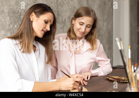 Learning calligraphy in art workshop. Teacher and students. Art school handwriting Stock Photo