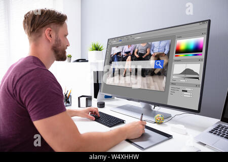 Designer Editing Photo On Computer In Office Stock Photo