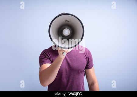 Close-up Of A Beard Man Shouting Through A Megaphone Against Gray Background Stock Photo