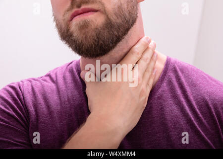 Close-up Of A Beard Man Touching His Sore Throat Stock Photo