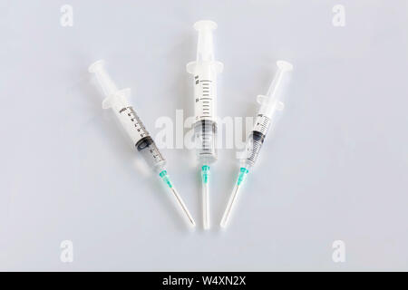 Three syringes of different capacity on the table in the hospital, prepared for injection, copyspace for the text below. Stock Photo