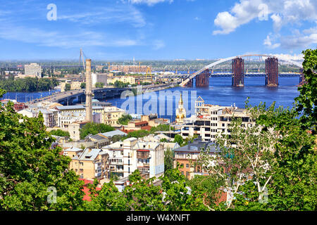 The Dnipro River with various bridges on a bright summer day and a view of the old Podol district of the city of Kyiv. Stock Photo