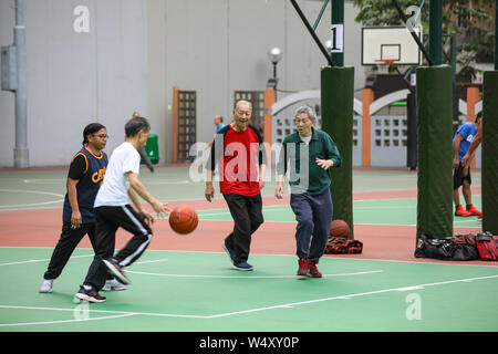 Older men playing basketball on Southorn Playgroung in Wan Chai, Hong Kong Stock Photo