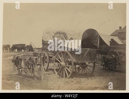 Covered wagon for ‘Headquarters baggage‘ and saddlery, probably a Civil War military camp Stock Photo