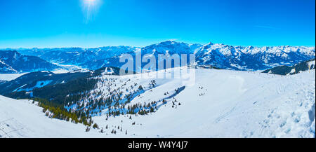Observe the gentle snowy slopes of Schmitten mount with comfortable ski pistes and snowshoe routes, spruce forests and sharp rocks, Zell am See, Austr Stock Photo