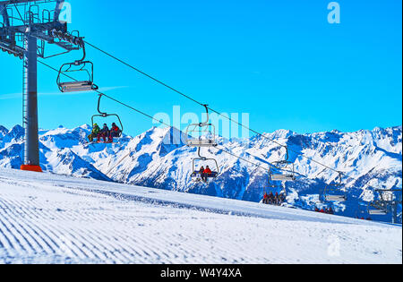 ZELL AM SEE, AUSTRIA - FEBRUARY 28, 2019: Fast running cabins of Kapellenbahn chairlift on the top of snowbound Schmittenhohe mount, covered with nume
