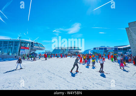 ZELL AM SEE, AUSTRIA - FEBRUARY 28, 2019: The upper stations of cableway routes of Zell am See air lifts network surround the crowded zone on slope of