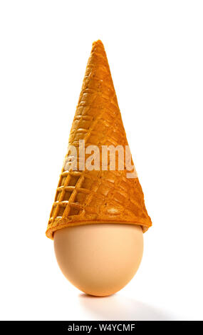 upside down ice cream cone with an egg on white background Stock Photo