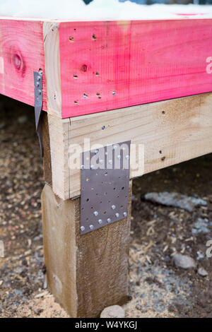 A gang-nail joint connecting the timber framing to the wooden piles on a new house's foundations on a building site in New Zealand Stock Photo