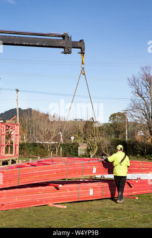 Sheffield. Canterbury, New Zealand, July 25 2019: Builders unload roof trusses that have been delivered by a Hiab truck to a building site Stock Photo