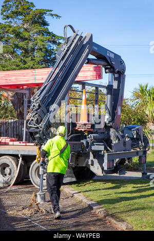 Sheffield. Canterbury, New Zealand, July 25 2019: Builders unload roof trusses that have been delivered by a Hiab truck to a building site Stock Photo