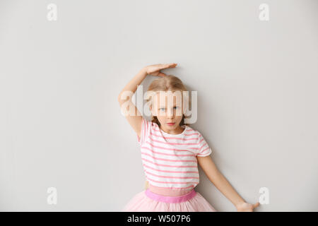 Cute little girl measuring height near wall Stock Photo