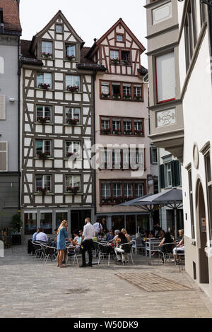 Customers sit outside on a warm Swiss day in St. Gallen's old town. Stock Photo