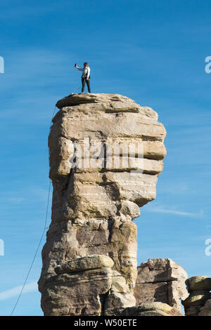 Woman climber on pillar of gneiss, Catalina Mountains, Arizona -taking a selfie. Stock Photo