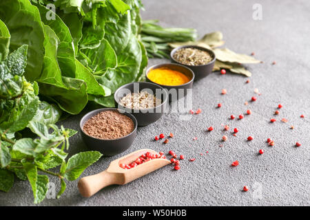 Different herbs and spices on grey background Stock Photo