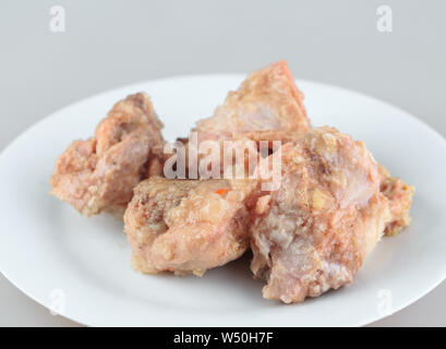Canned meat in a white plate on white background Stock Photo