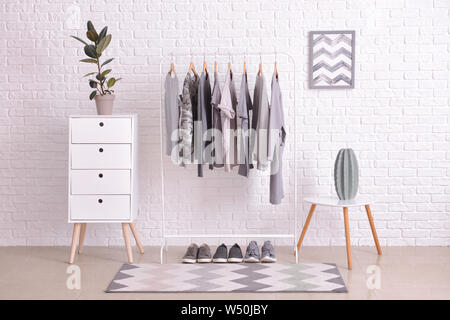 Rack with hanging clothes in interior of dressing room Stock Photo