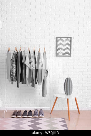 Rack with hanging clothes in interior of dressing room Stock Photo