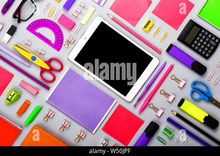 Modern tablet computer with stationery on grey background Stock Photo