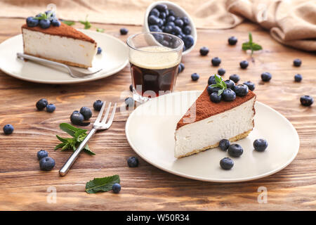 Plates with tasty cake and blueberry on wooden background Stock Photo