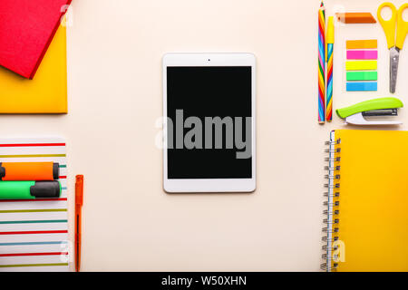 Modern tablet computer and school supplies on light background Stock Photo