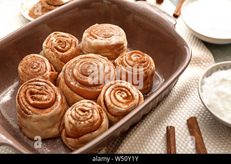 Baking tray with tasty cinnamon buns on table Stock Photo