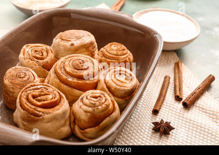 Baking tray with tasty cinnamon buns on table Stock Photo