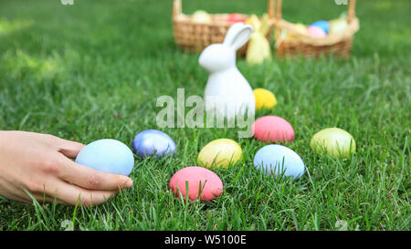 Woman gathering Easter eggs outdoors Stock Photo