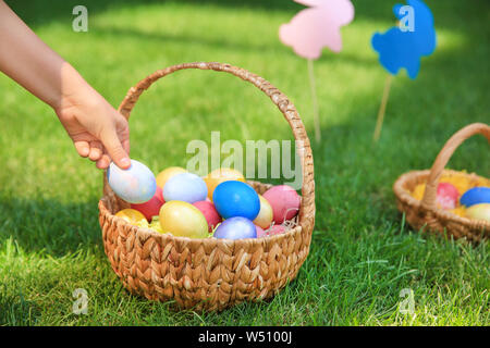 Woman gathering Easter eggs outdoors Stock Photo