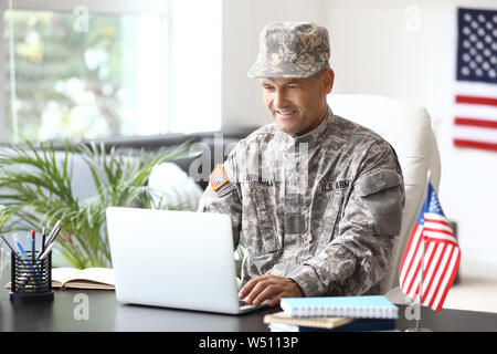 Mature male soldier working with laptop in headquarters building Stock ...