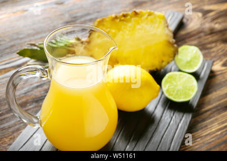 Jug of fresh pineapple juice on table Stock Photo