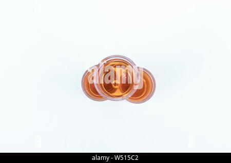 Top view of three whiskey cups stacked vertically on a white background - Tasty and luxurious whiskey - Close-up Stock Photo